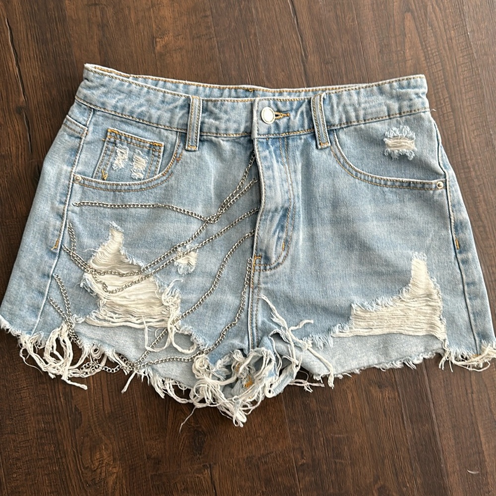 Shredded jeans short dangling chain. Never worn size 6.